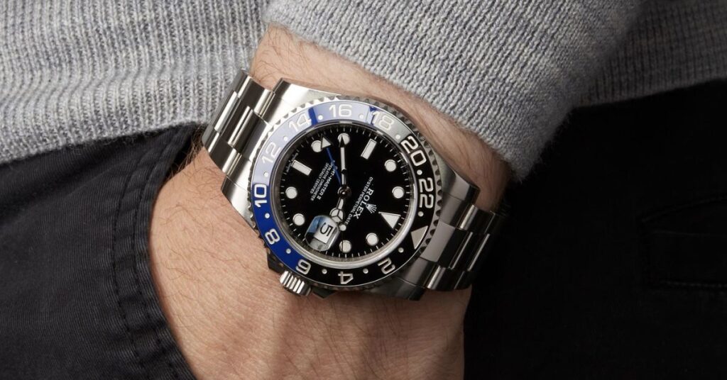 a person wearing a rolex batman gmt master